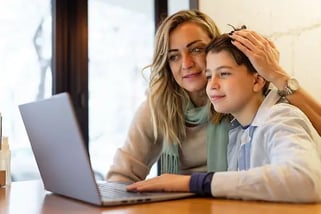 Royalty Free Mom and Son Looking at Schools Online